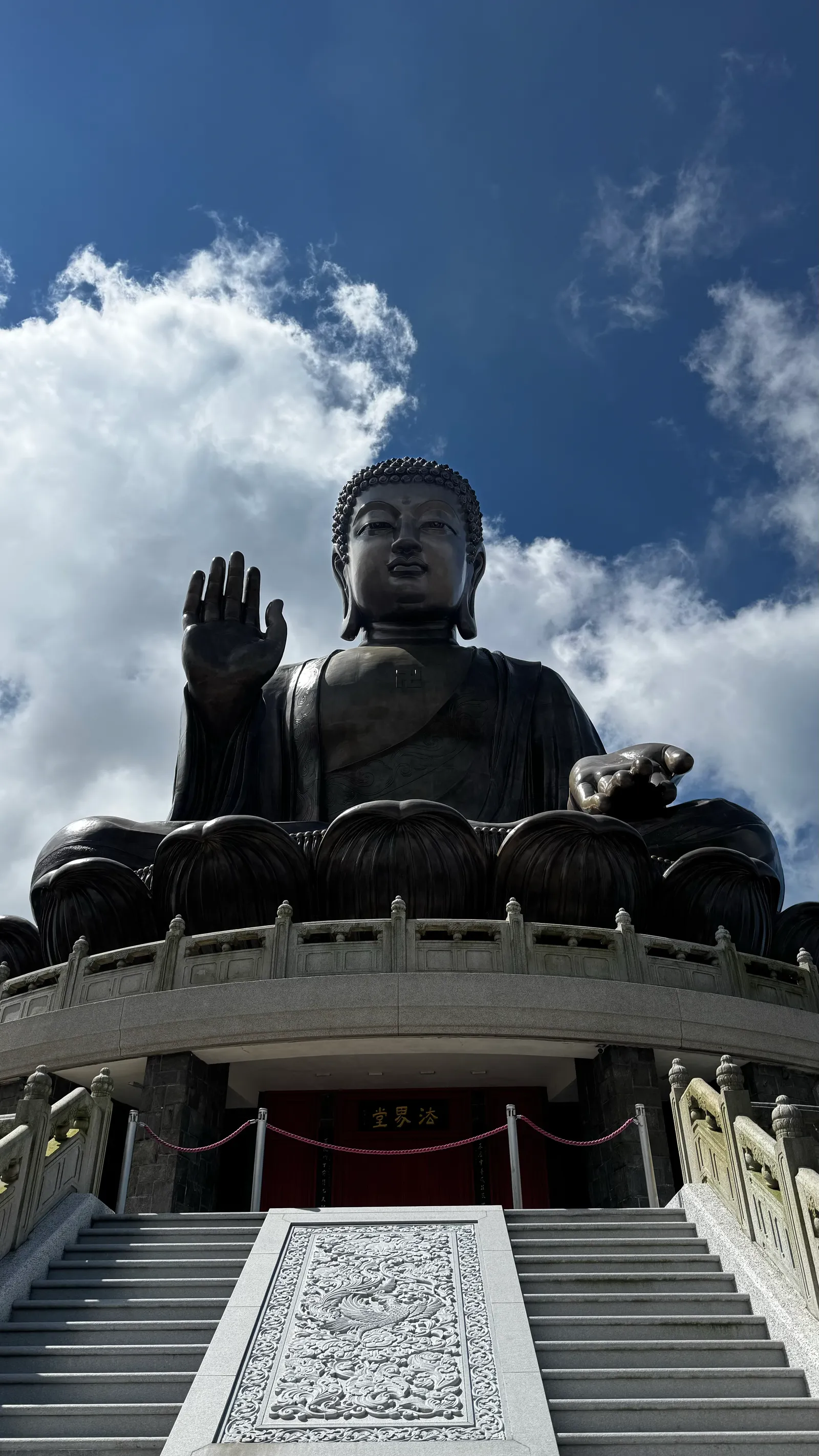 Le Grand Bouddha de Tian Tan, main levée, sous les nuages