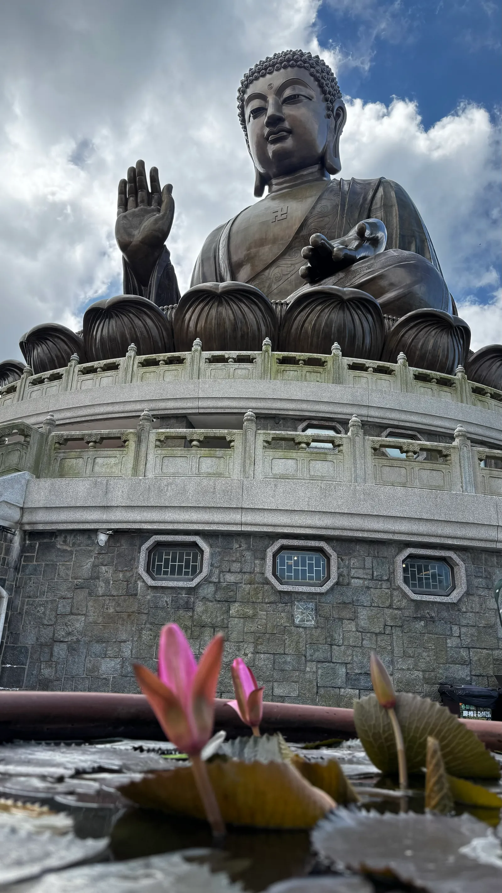 Le Bouddha et un lotus, au pied du socle