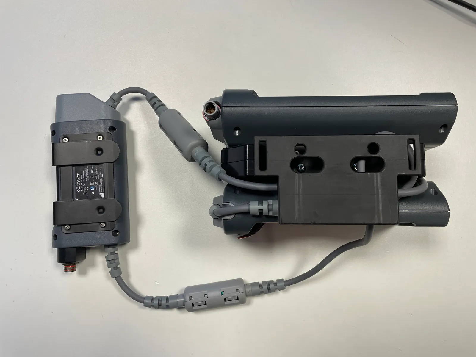 Le système externe que porte le patient : contrôleur et batteries amovibles, reliés à la prothèse.