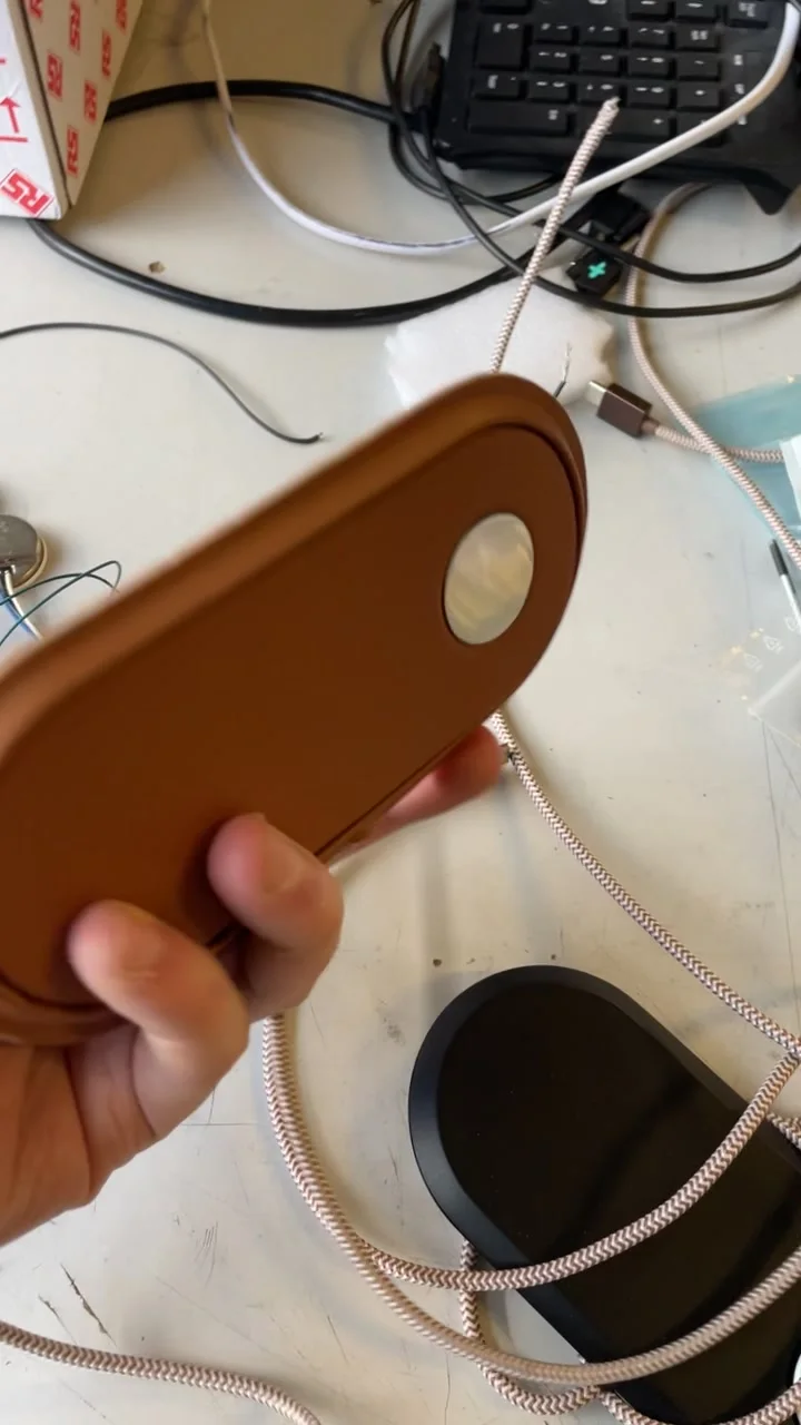 Le plateau en cuir et sa zone de charge Apple Watch, à côté de la carte électronique, sur l'établi.